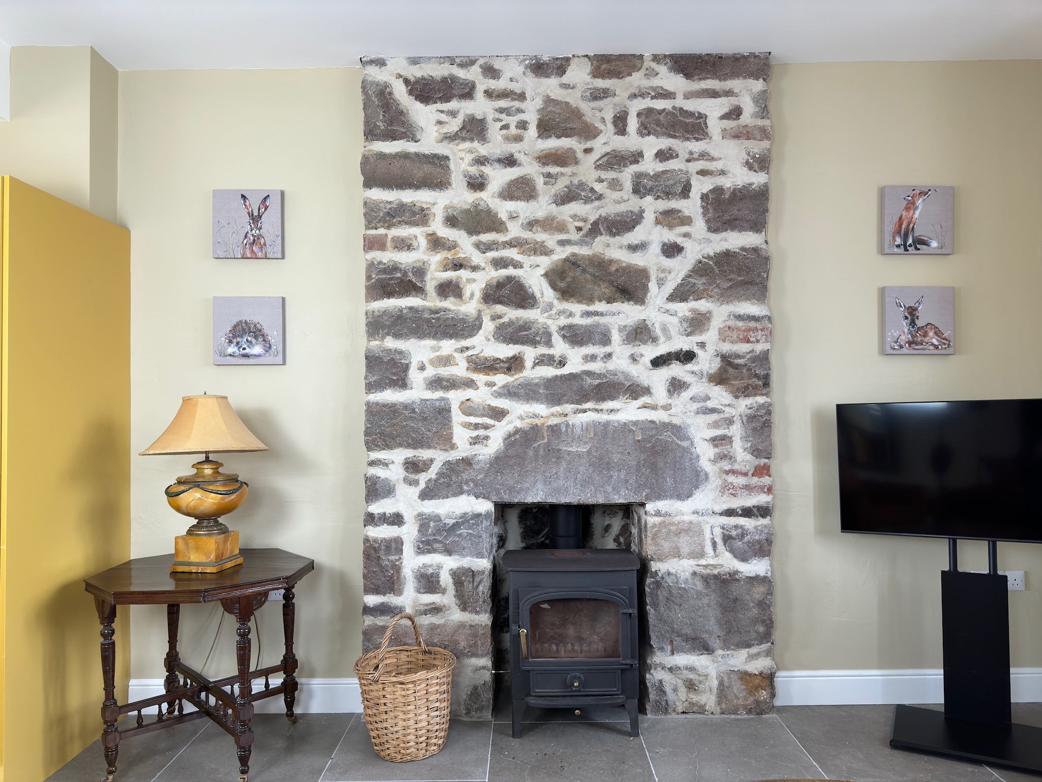 Living room with stone fireplace and wildlife art