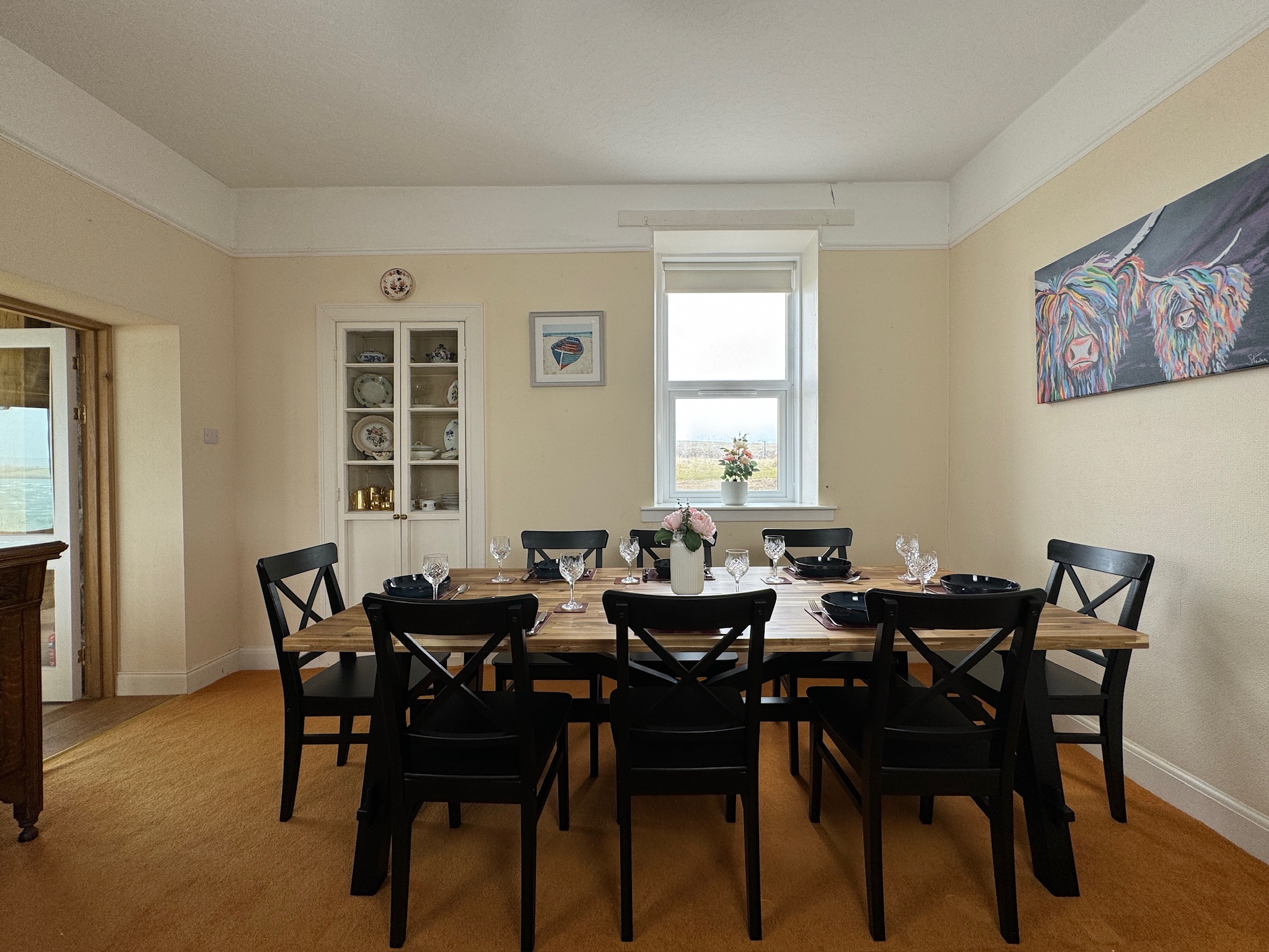 Dining room with set table and Highland cow artwork