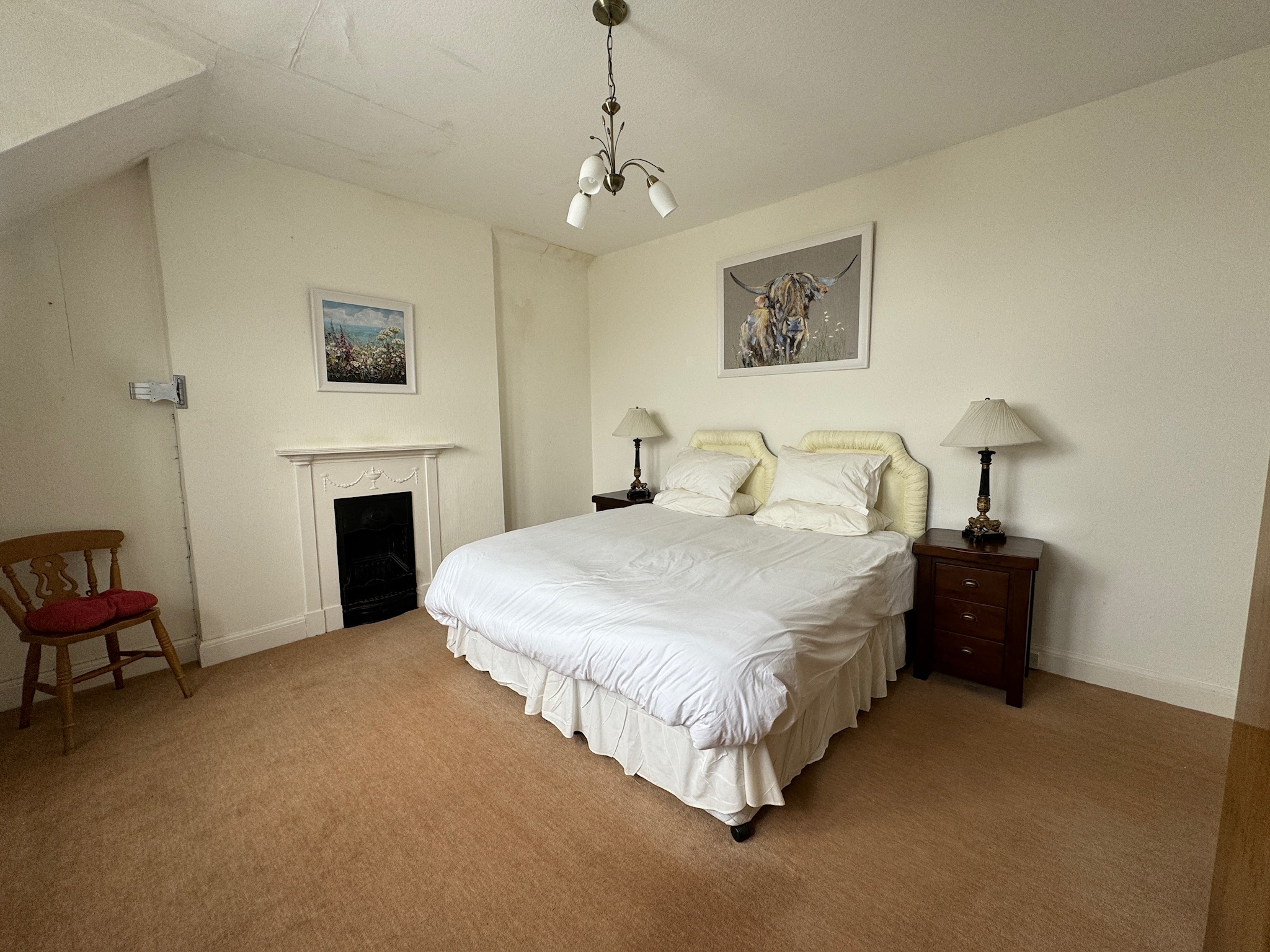Bedroom with fireplace and Highland cow artwork