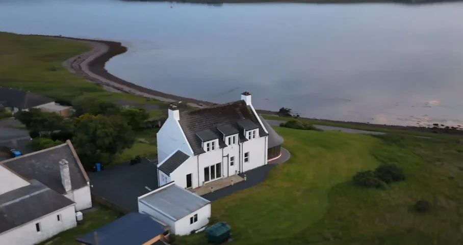Aerial view of Scottish Cottage near the coastline with Loch Ewe in the background